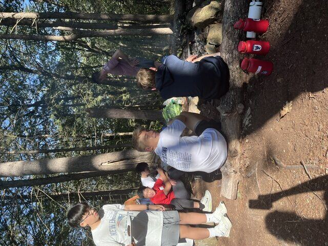 Briggs at a campfire with classmates