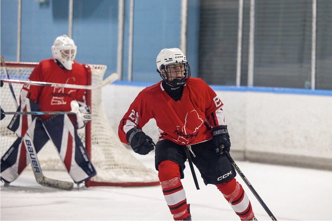 Briggs skating in NEFPHL game action with goalie